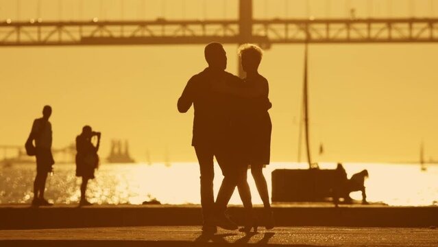 Silhouette of elderly couple dancing at sunset