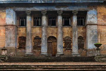 Old abandoned building with columns on a cloudy day