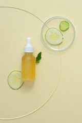 Unlabeled serum bottle containing yellow liquid, cucumber slices displayed on a petri dish. Advertisement for cosmetics containing cucumber extract.