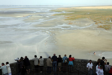Tourists looking at the sandy bay - Mont Saint Michel - Normandy - France