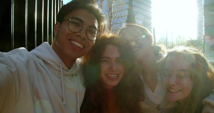 Selfie perspective of a group of teenagers enjoying in a city during sunset