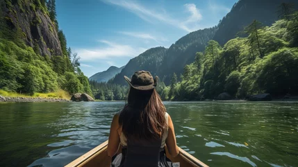 Foto op Canvas Back view of young blonde woman traveling a boat on beautiful mountain river among mountains. Girl traveler in a hat on a boat on the background of mountains on an azure mountain river. Travel concept © Valua Vitaly
