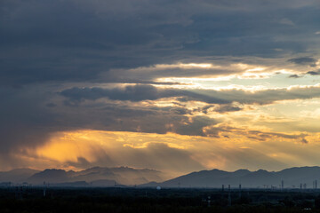 The rays of the sun break through the clouds, mountains in the fog after the rain in the background