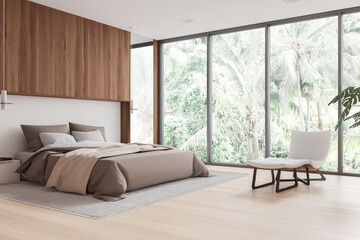 Stylish hotel bedroom interior with bed, armchair and panoramic window