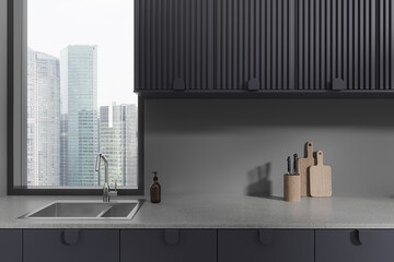 Grey home kitchen interior with sink, counter with kitchenware and shelves