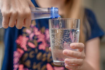 Woda w butelce plastikowej nalewana do szklanki