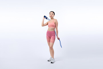 Young energetic asian woman in sportswear with jumping or skipping robe posing portrait in studio...