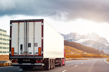 Cargo Semi Truck in the Mountains. Delivery freight truck on the Europe motorway. Global delivery concept. On the Road to Delivery