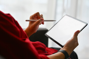 Young creative man holding stylus pen writing on digital tablet screen