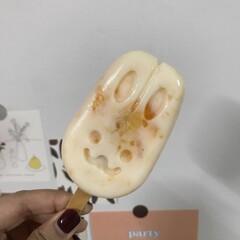 a hand holding orange ice cream