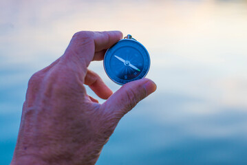 Compass with a person's hand showing direction Outdoor concept