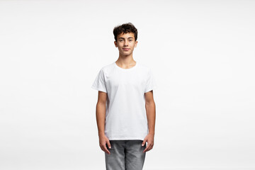 Portrait of attractive curly haired boy wearing white t shirt, jeans isolated on white background, mockup  