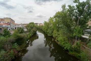 Views of the Jerte river in the town of Plasencia with the trees and vegetation reflecting.