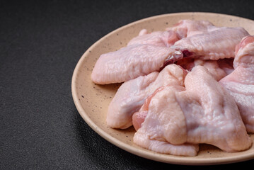 Fresh raw chicken wings with salt and spices prepared for baking