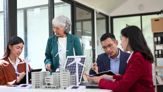Business people having consultation about wind energy at company office. Business team discussing about windmill and alternative green enery. Executive meeting at office.