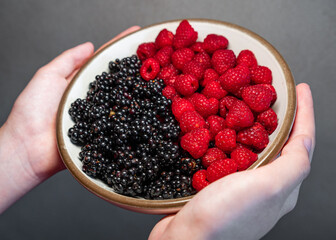 Summer berries, raspberries, blackberries. Dessert on a white plate. Vitamins, healthy nutrition....