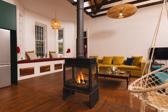 Contemporary luxury domestic living room, with swing chair and central wood burner, copy space