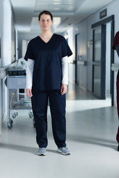 Portrait of happy caucasian female doctor wearing scrubs in hospital