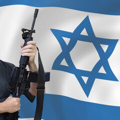 Hands of a man holding an automatic rifle on the Israeli flag bokeh. Civil self-defense