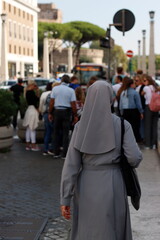 Nun walking in a steet of Rome