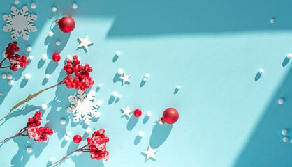 Beautiful light blue Christmas background with red berries and snowflakes. New Year's composition...