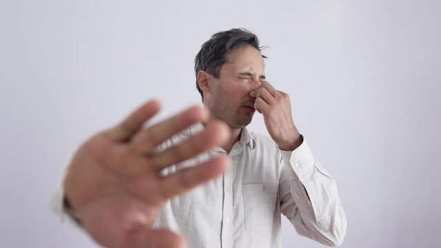 Bad smell concept. Man covers his nose with his hand