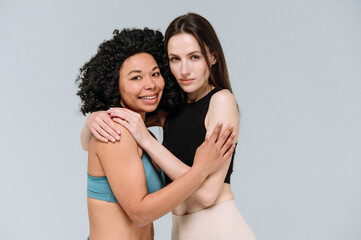 Fototapeta premium Caucasian and african american models in activewear hugging