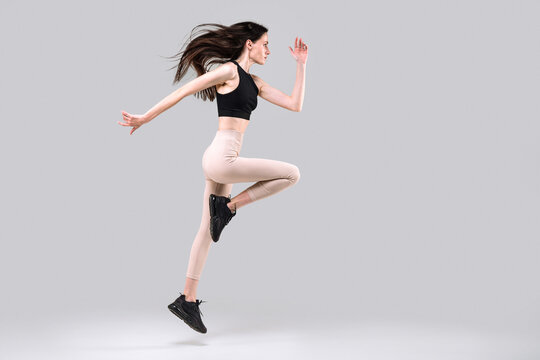 Focused woman in motion jumping over in the air