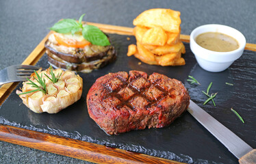 Delectable Medium Well Filet Mignon Steak with Grilled Vegetables on Hot Stone Plate