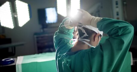 Biracial female surgeon wearing face mask in operating theatre at hospital, slow motion