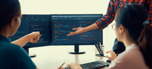 Young Professional website developer and cooperative computer engineer team brainstorming and sharing idea of program writing and coding at modern meeting room. Teamwork concept. Closeup. Burgeoning.