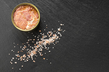 Bef meat in metal can, canned meat, open can, close up, black background, space for text, cherry tomatoes pepper and see salt