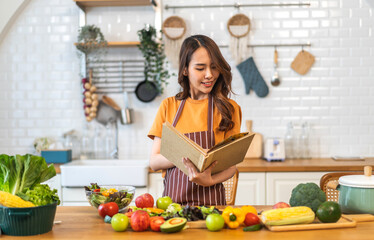Portrait of beauty body slim healthy asian woman having fun cooking and preparing vegan food healthy eat with fresh vegetable salad, vegetarian on counter in kitchen at home.Diet.Fitness, healthy food