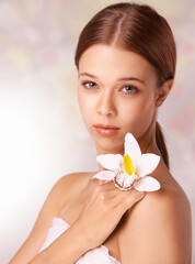 Obraz na płótnie Canvas Woman, portrait and flower for wellness in studio, beauty and skincare for care, elegant and cosmetic. Female model person, floral and brunette or spa treatment, organic body care and background