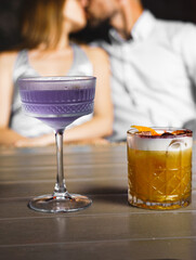 A couple in love drinks a cocktail and smokes a hookah on the terrace at night. Nightlife concept