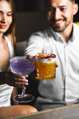 A couple in love drinks a cocktail and smokes a hookah on the terrace at night. Nightlife concept