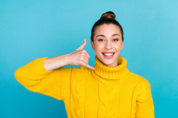 Portrait of attractive cheerful girl showing gesture phone hot line center isolated on shine color...