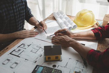 engineer is in planning meeting with architect about building a house,  Draw structural of buildings at the meeting and discuss together,  Design blueprints for use in structural work, architect idea.