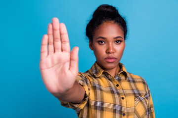 Lady making stop gesture with her palm, on a blue background