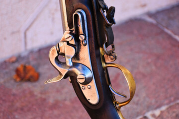 old vintage muzzleloading flintlock rifle closeup. shiny metal flint, frizzen and cock and lock...