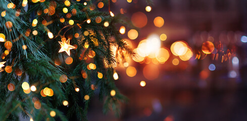 Christmas tree with garland lights. Evening city with blurred background and bright lights - 669104994
