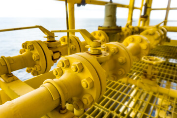 Small yellow valves placed next to each other control the flow of outdoor oil pipelines.