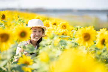 ヒマワリ畑で遊ぶ少女