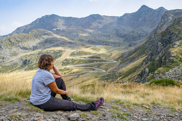 curvy young caucasian girl sitting relaxed thoughtful resting after reaching the top of tristaina...