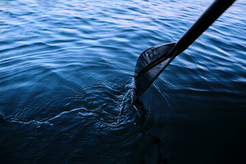 Close-up of an oar against the water.