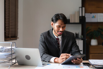 Businessman writing business data on tablet while analyzing strategy of startup business project