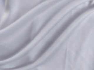 White and gray satin fabric has wavy folds and blurred patterns. beautiful and natural