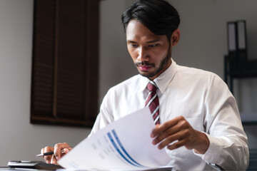 Businessman use calculator to checking marketing paper and analyzing strategy of startup business