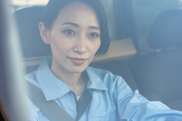 ガラス越しに笑顔で運転する女性