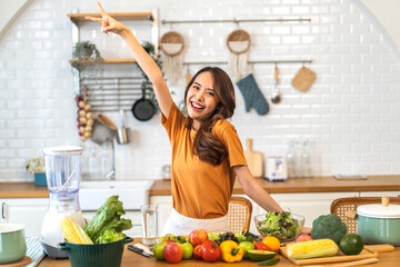 Portrait of beauty body slim healthy asian woman having fun cooking and preparing vegan food healthy eat with fresh vegetable salad, vegetarian on counter in kitchen at home.Diet.Fitness, healthy food